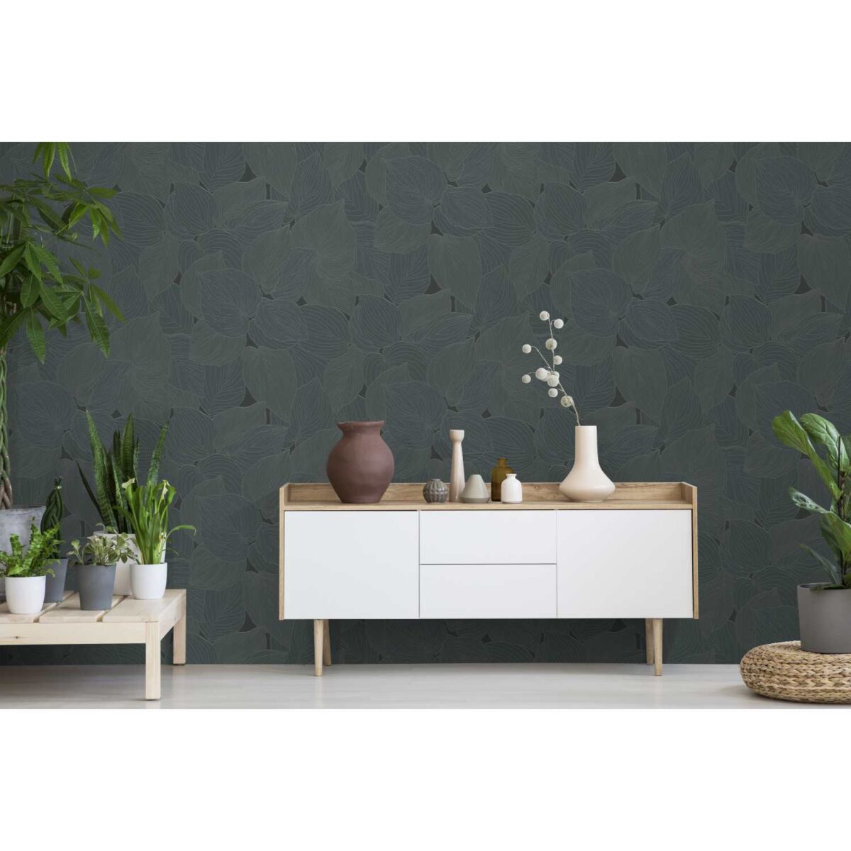 Real photo of a botanic living room interior with burlap artwork on the gray wall and white cupboard surrounded by plants